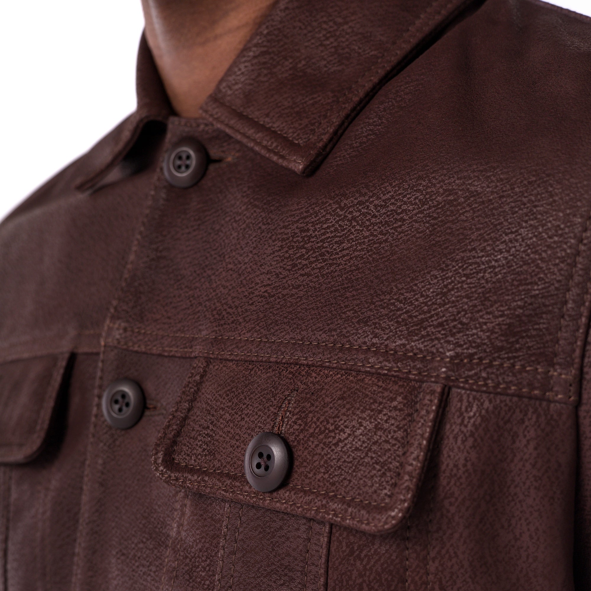 Close-up of a brown leather jacket with buttons on a white background