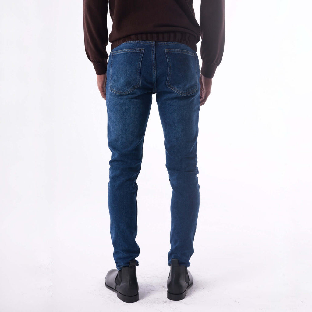 Person wearing blue jeans on a white background