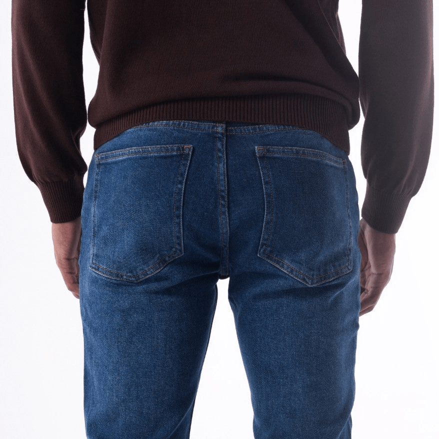Back view of SOLID stone washed slim jeans in dark wash, styled with a brown sweater.