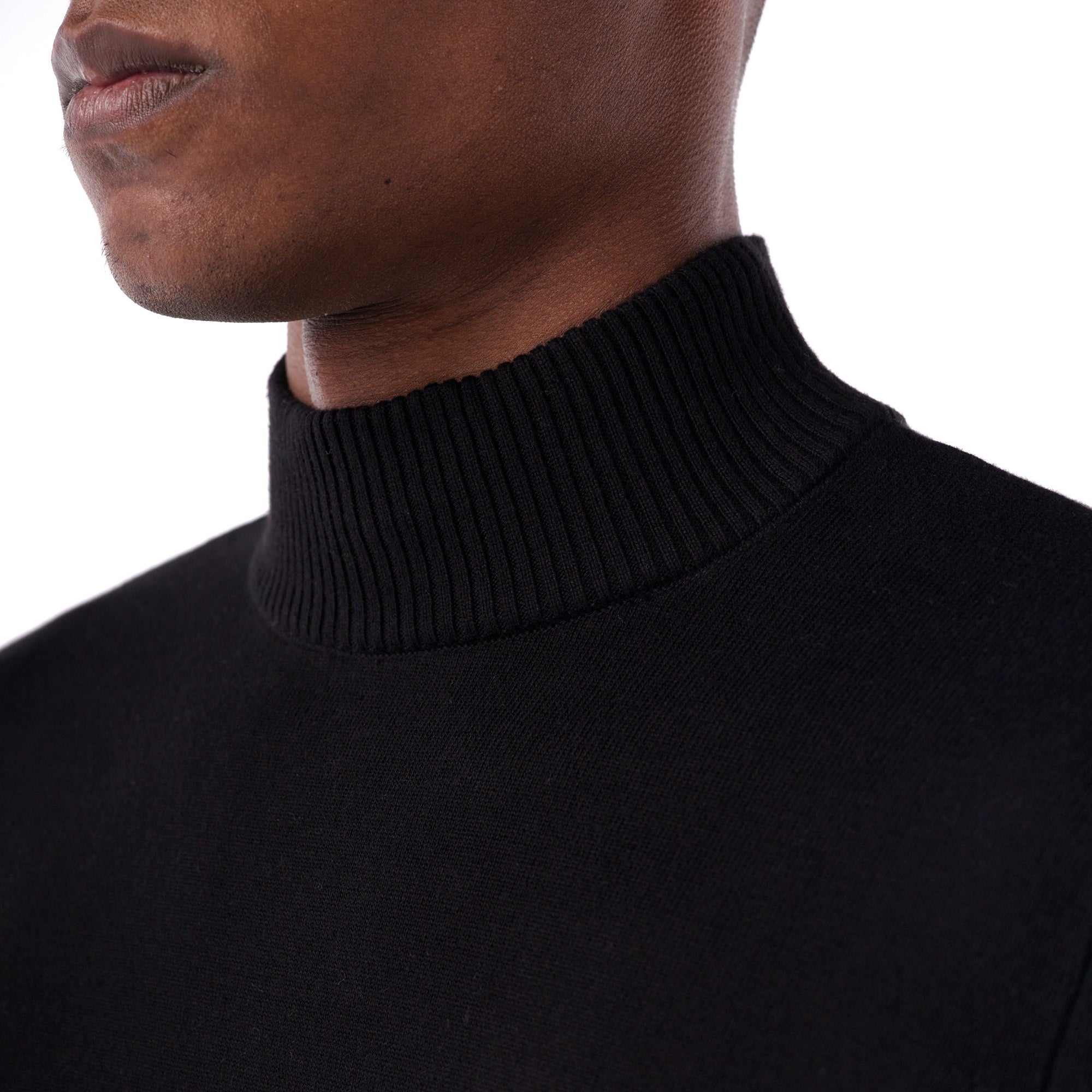 Close-up of a person wearing a black turtleneck sweater on a white background