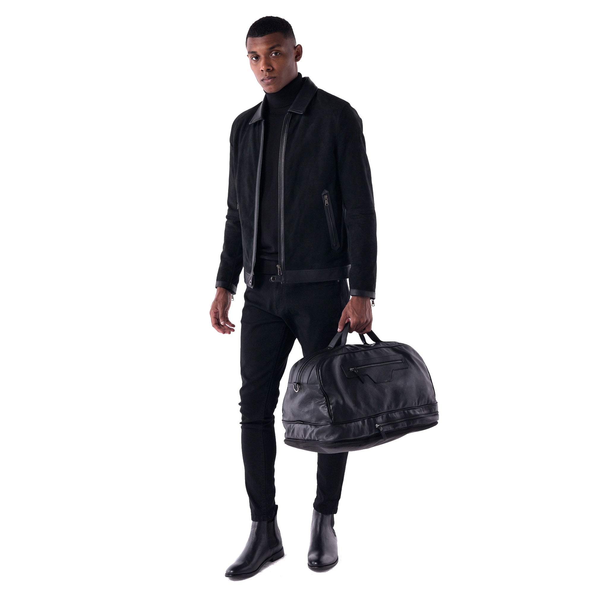 Man holding a black leather duffel bag against a white background