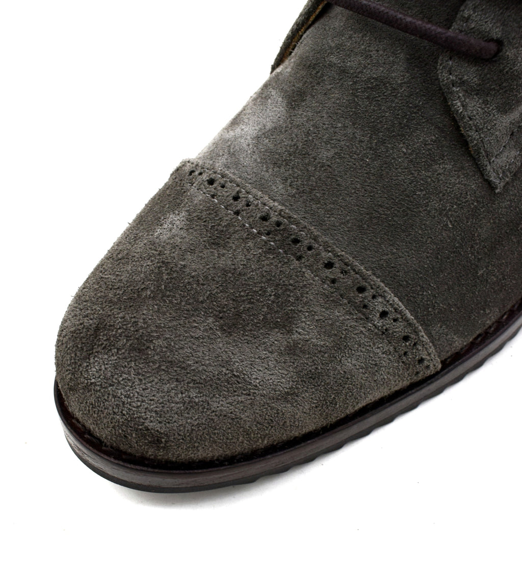 Close-up of a gray suede shoe on a white background