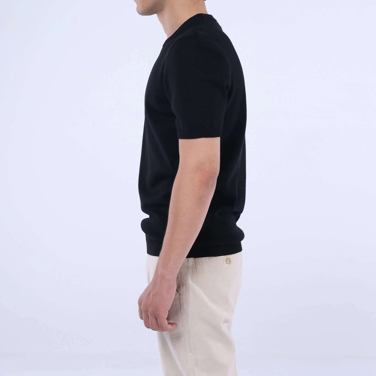 Side view of a man wearing a CloudKnit Crew Tee in black, showcasing its ultra-soft premium cotton material.