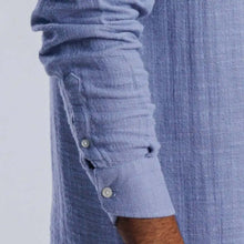 Load image into Gallery viewer, Close-up of blue collarless linen-blend shirt sleeve showcasing button details and textured fabric.
