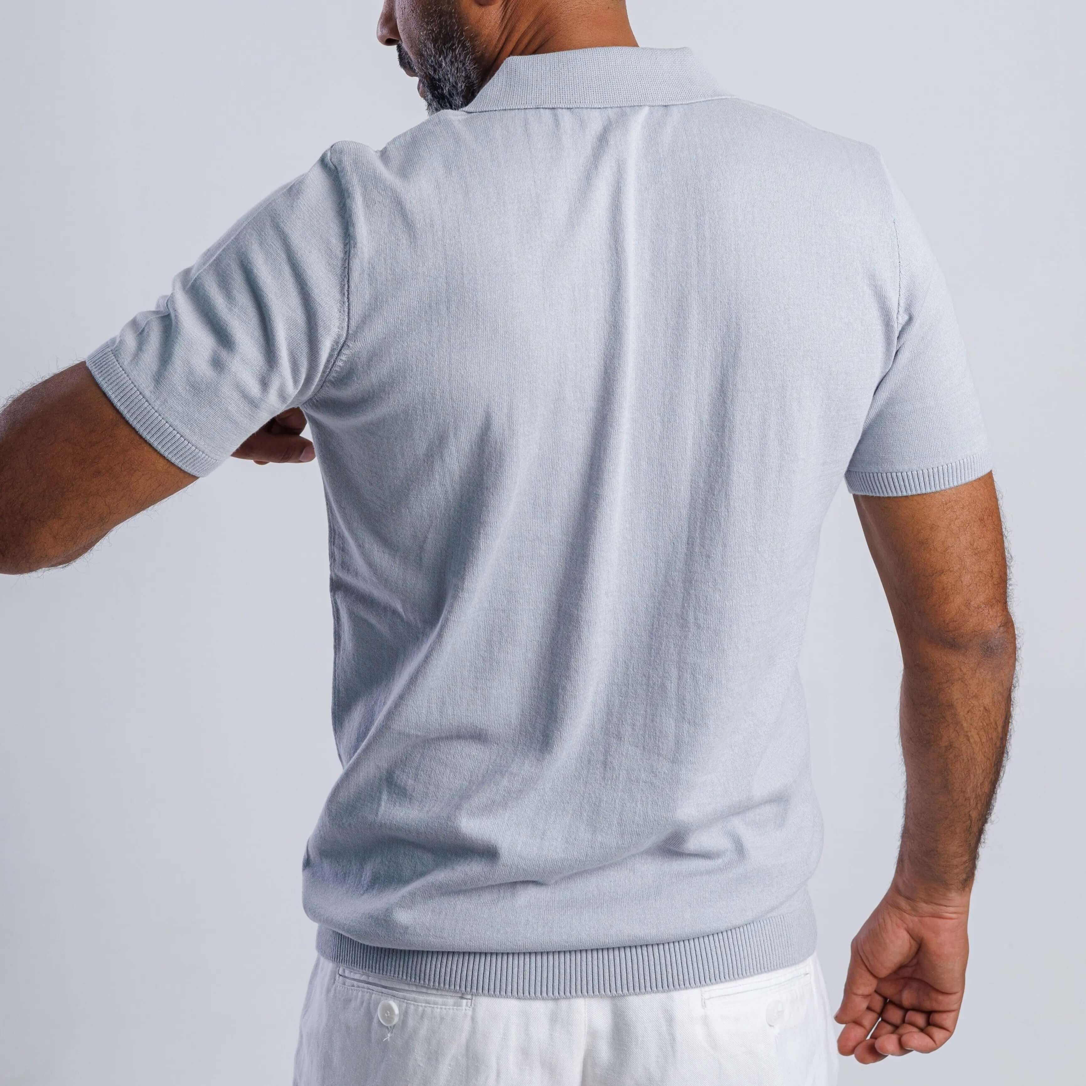 Man wearing light blue ComfortLite™ Knit Polo, showcasing the breathable fabric and all-day comfort.