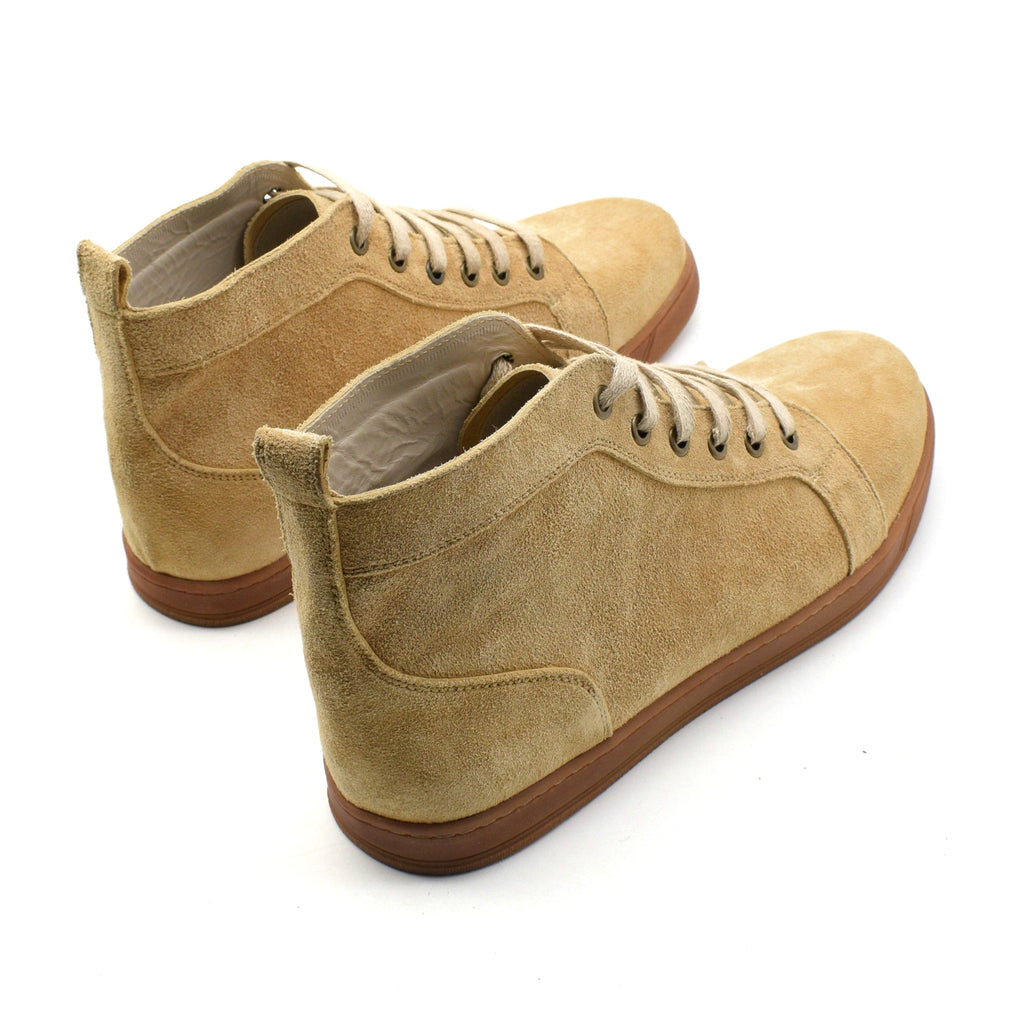 Pair of beige suede shoes with gum soles on a white background