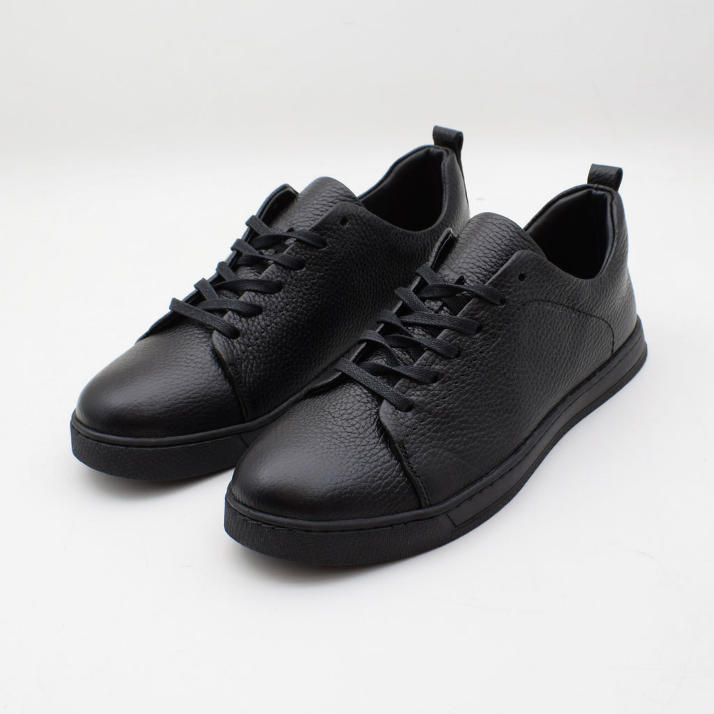 Pair of black leather sneakers on a white background