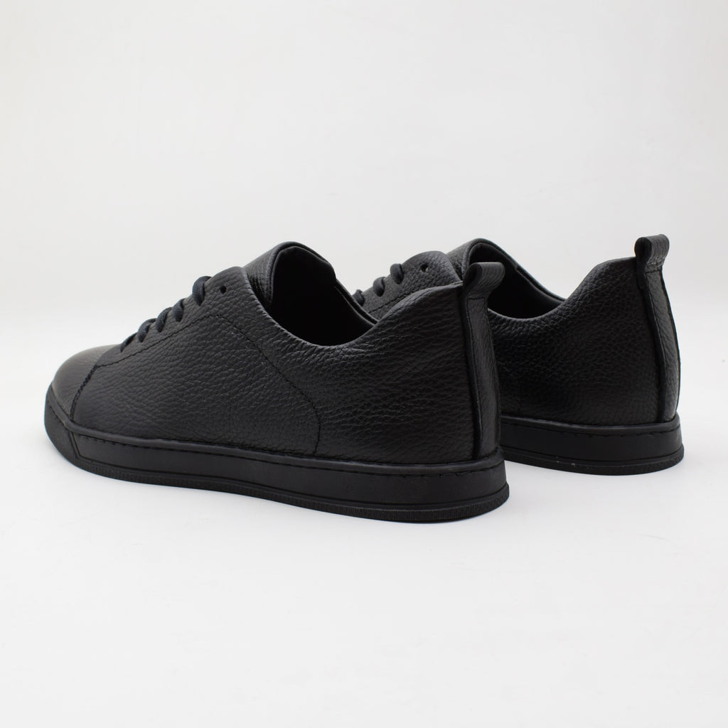 Pair of black leather sneakers on a white background