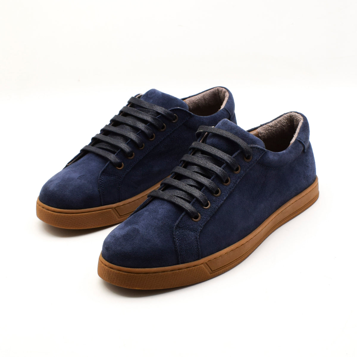 A pair of navy blue suede low-top sneakers with black laces and brown rubber soles, displayed on a clean white background.