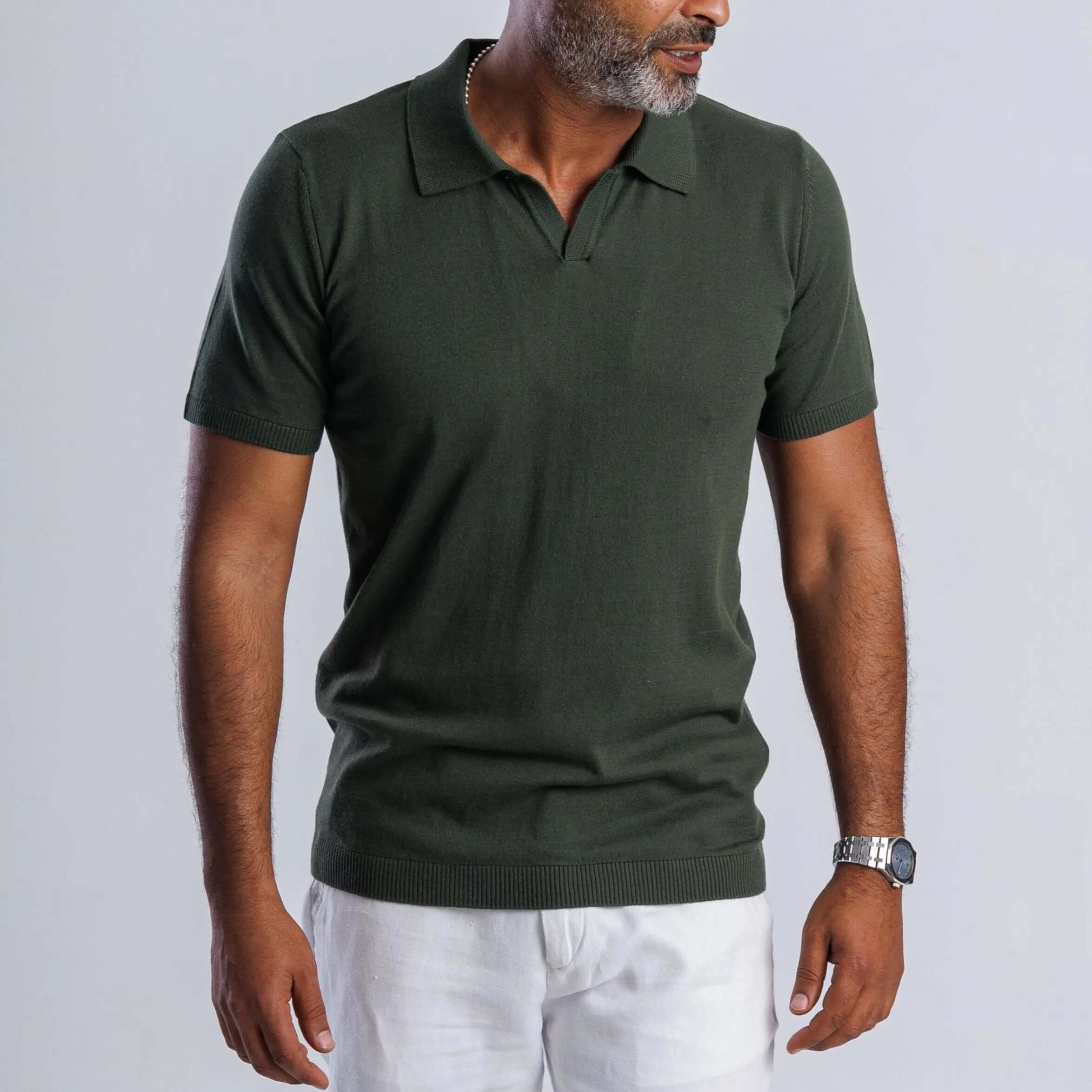 Man wearing a green FlowKnit™ Relaxed V-Neck shirt with short sleeves and a casual style.