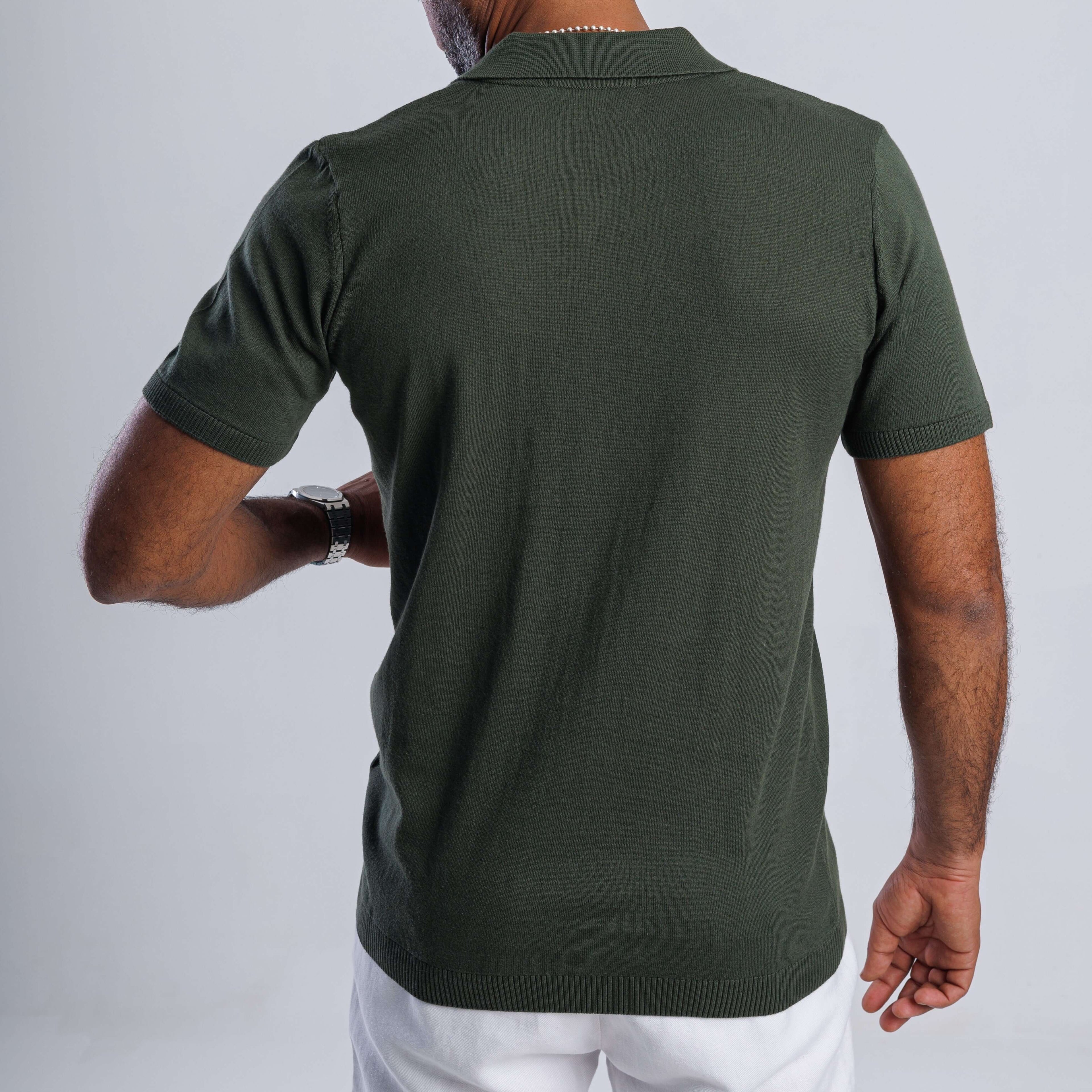Back view of a man wearing a green FlowKnit™ Relaxed V-Neck shirt, showcasing its minimalist style.