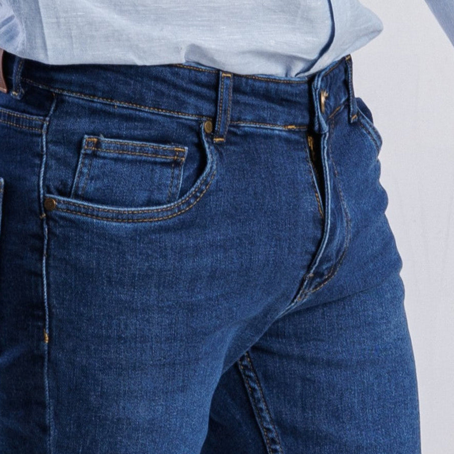 Close-up of blue jeans with a plain background
