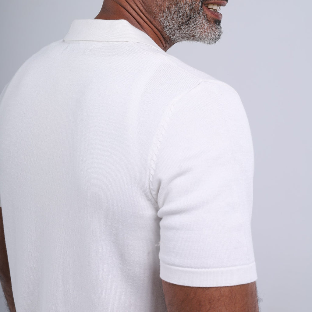 Man wearing a white polo shirt on a light gray background
