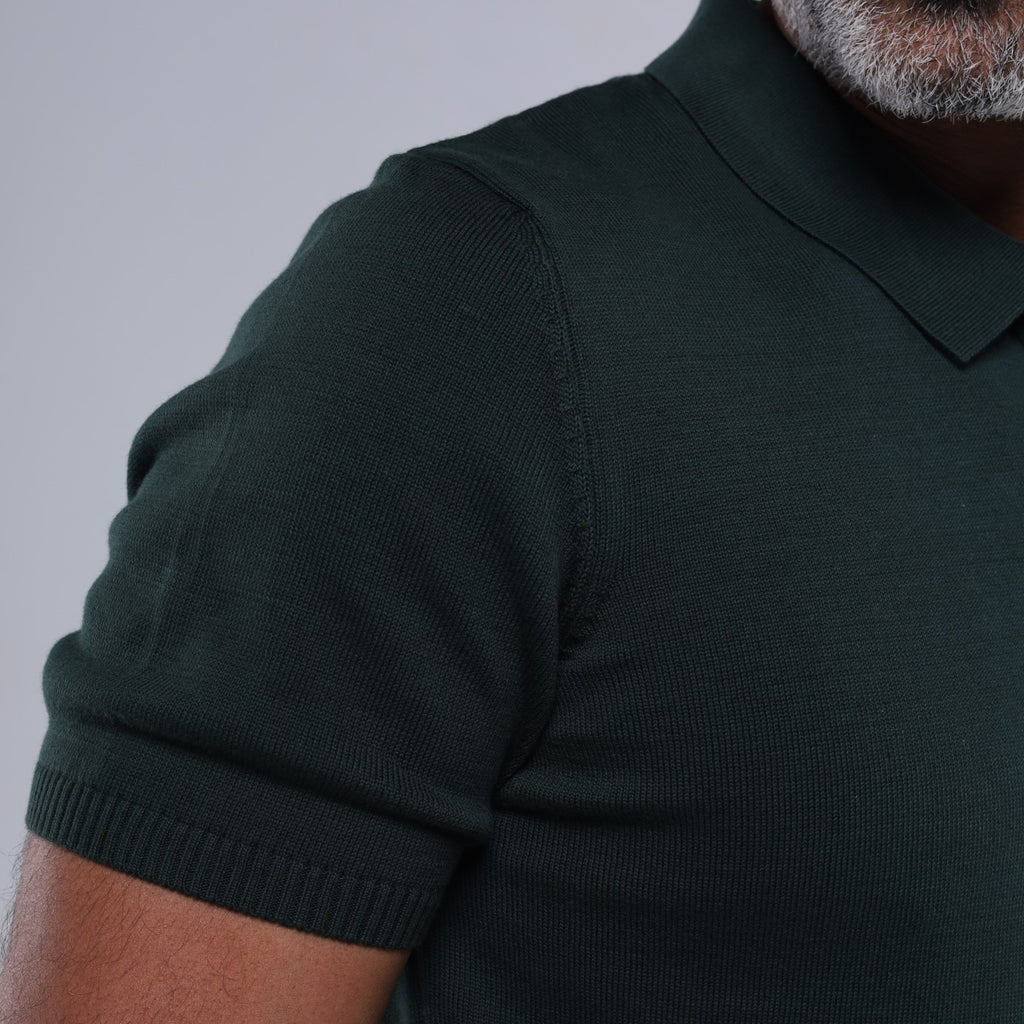 Dark green polo shirt worn by a person on a gray background