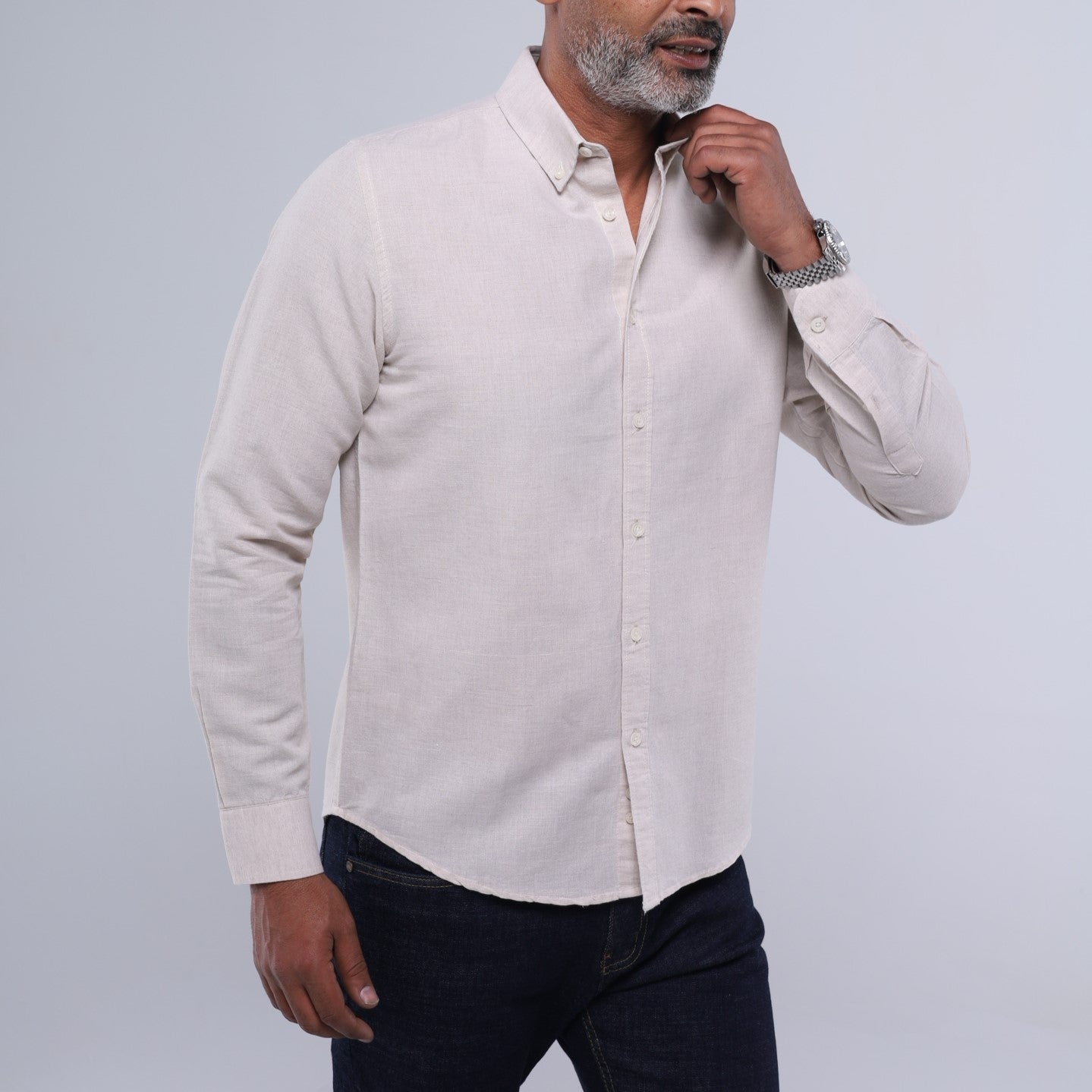 Man wearing a light-colored button-up shirt against a plain background