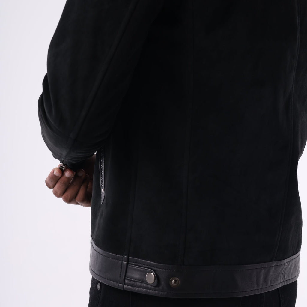 Close-up of a black jacket with leather trim on a white background