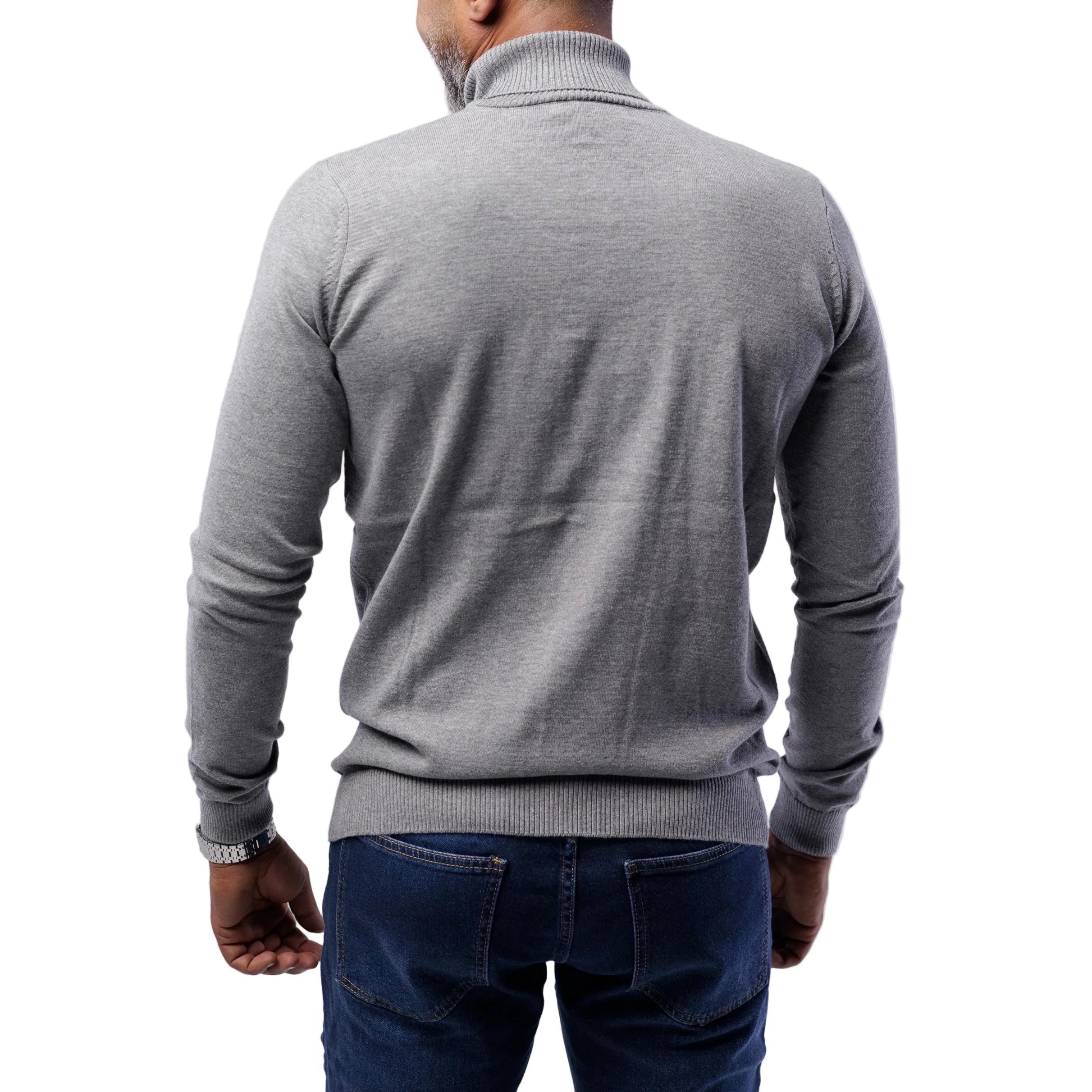 Person wearing a gray turtleneck sweater and blue jeans on a white background