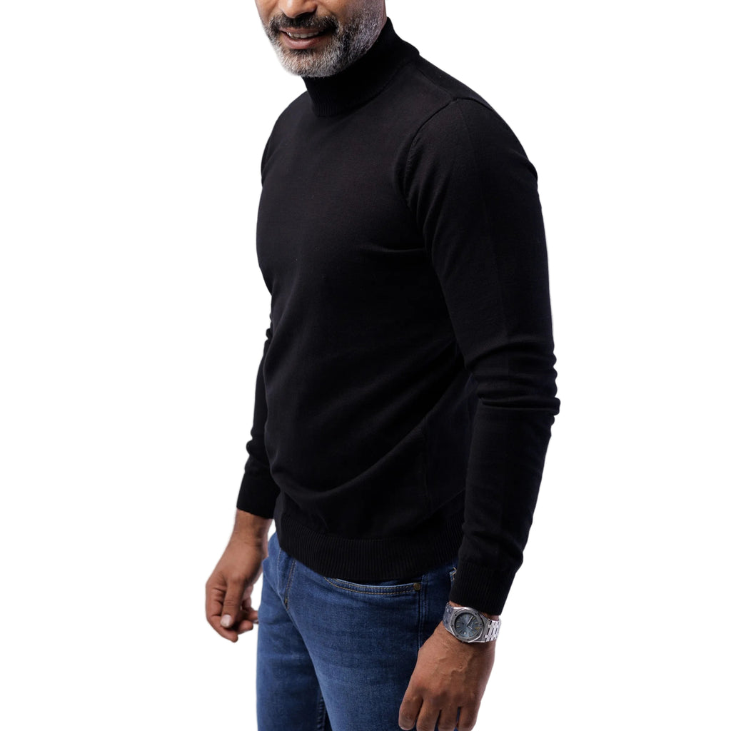 Man wearing a black turtleneck sweater and blue jeans on a white background