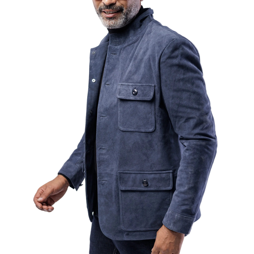 Man wearing a blue jacket with multiple pockets on a light gray background