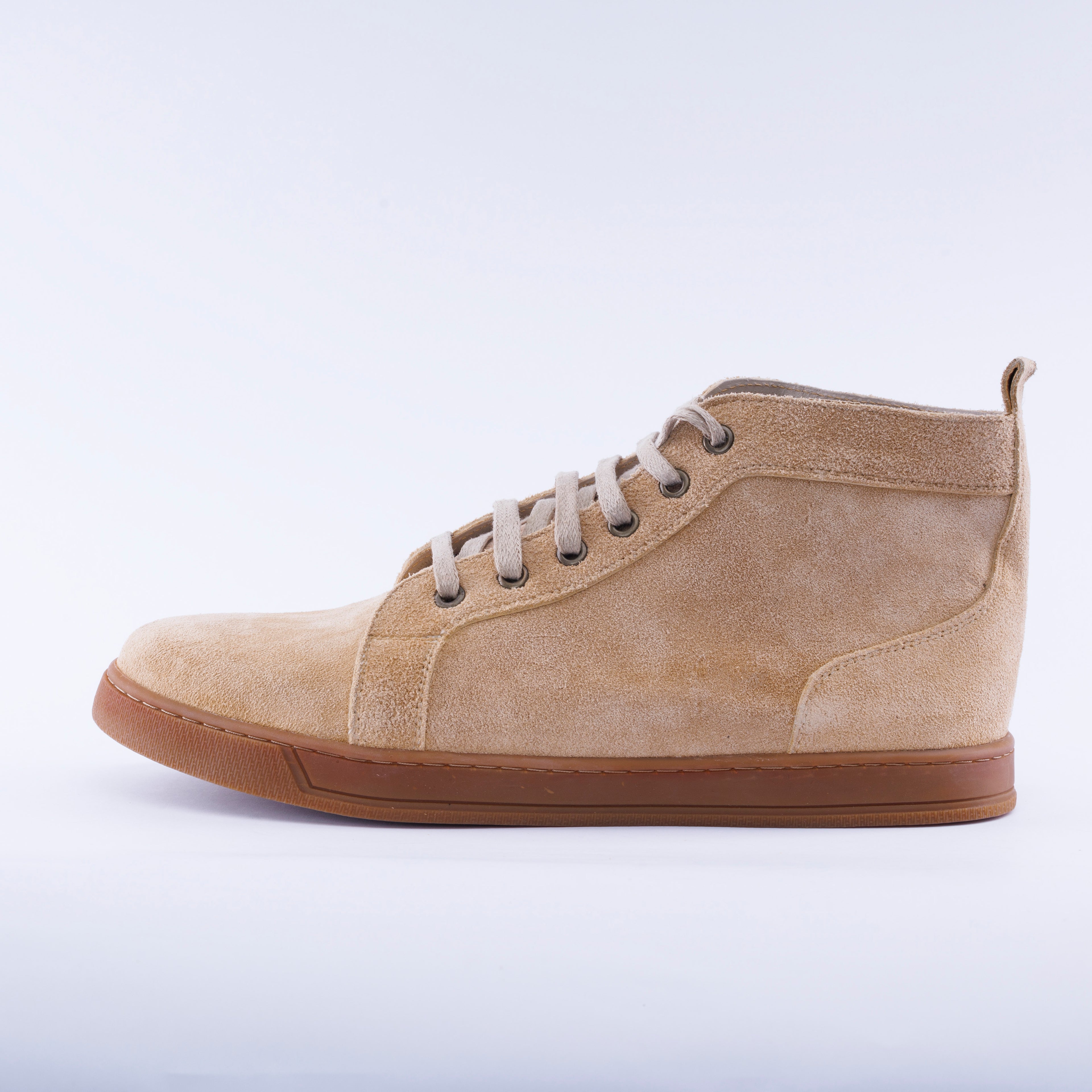 A light tan suede high-top sneaker boot with matching laces, dark metal eyelets, and a brown gum sole, shown in profile against a white studio background.