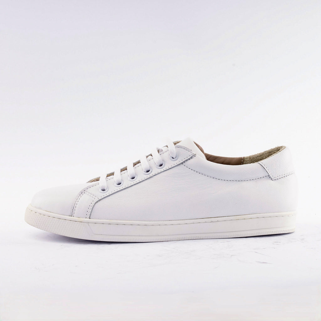 A white leather low-top sneaker with matching white laces and a white rubber sole, shown in a side profile against a clean white background.