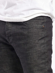 Dark gray jeans worn by a person on a white background