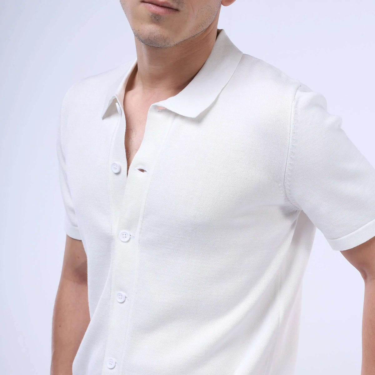Close-up of a man wearing a white Knit-Layer™ Short Sleeve Shirt, showcasing its lightweight fabric and button-up style.