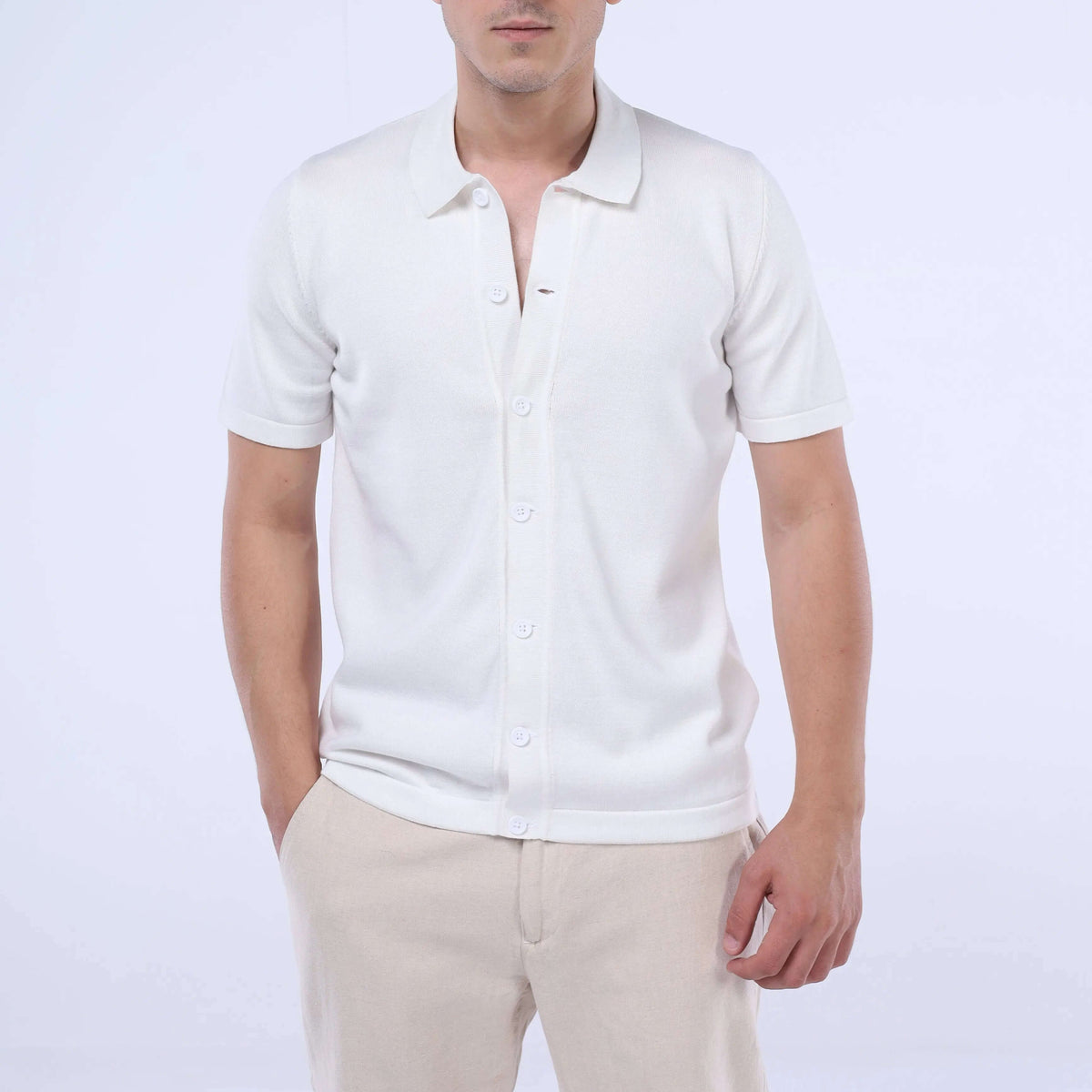 Model wearing a solid white Knit-Layer™ Short Sleeve Shirt, showcasing versatile summer style.