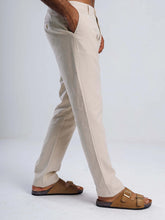 Load image into Gallery viewer, Man wearing linen blend tapered trousers with side pockets and stylish sandals, showcasing breathable fabric.
