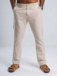 Beige linen blend tapered trousers with tailored fit, featuring side pockets and YKK zip fly, styled with sandals.