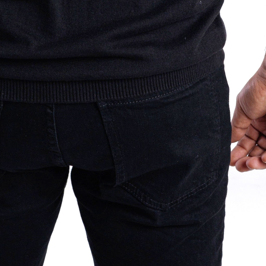 Close-up of black pants with a white background