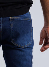 Load image into Gallery viewer, Close-up of the back pocket of Slim-Straight Flex Denim, highlighting its tailored design and comfort for everyday wear.
