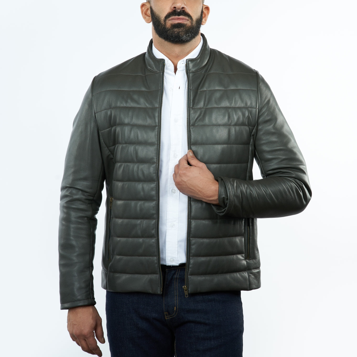 Man wearing a green puffer jacket over a white shirt on a white background