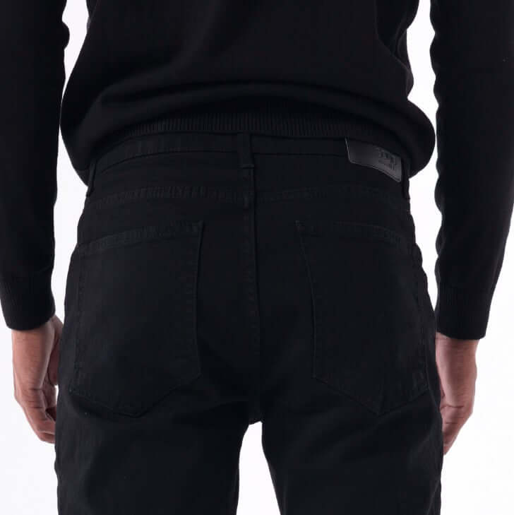 Back view of SOLID black skinny jeans showcasing a close fit and felled seams.
