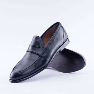 Black leather loafer shoe on a white background