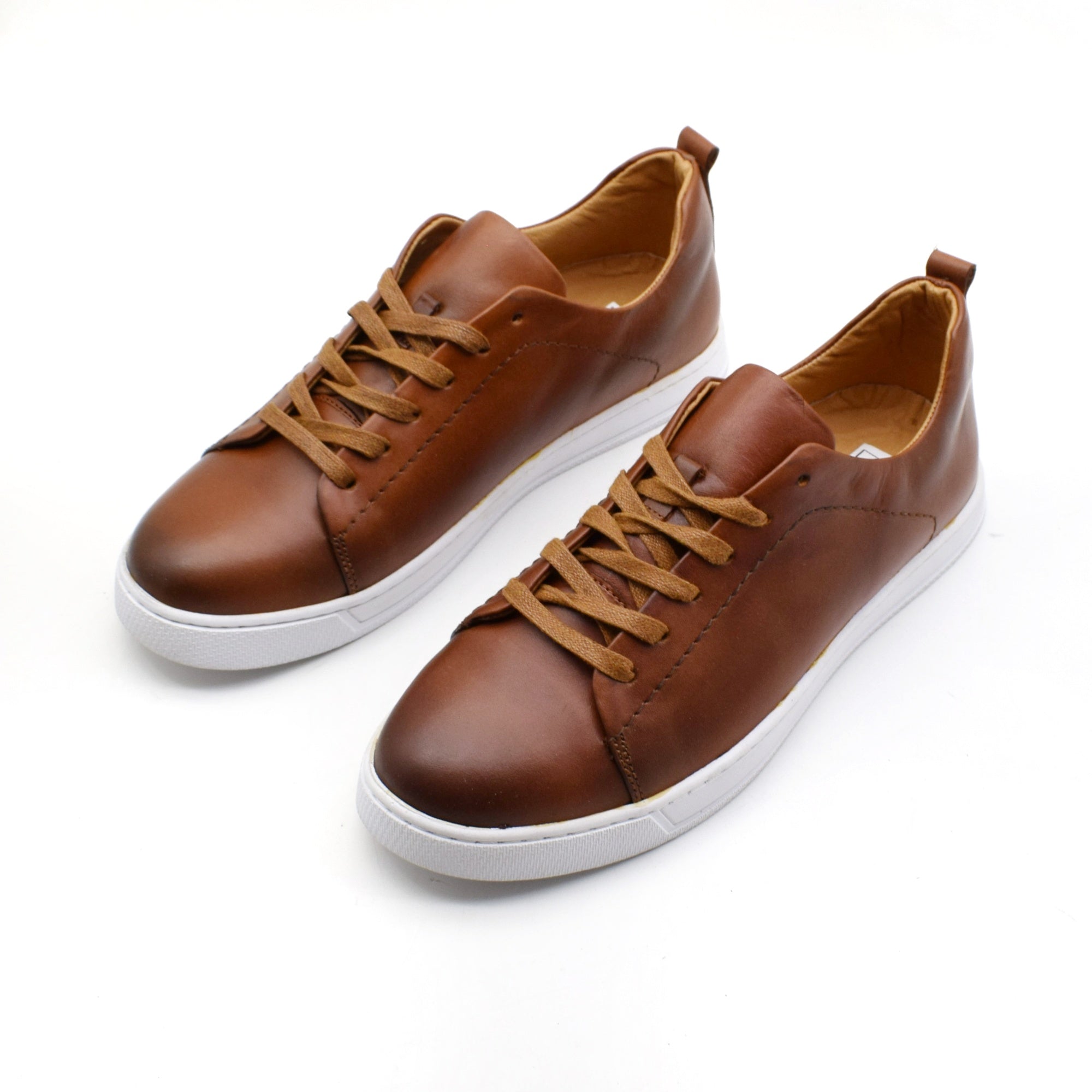 Pair of brown leather sneakers on a white background