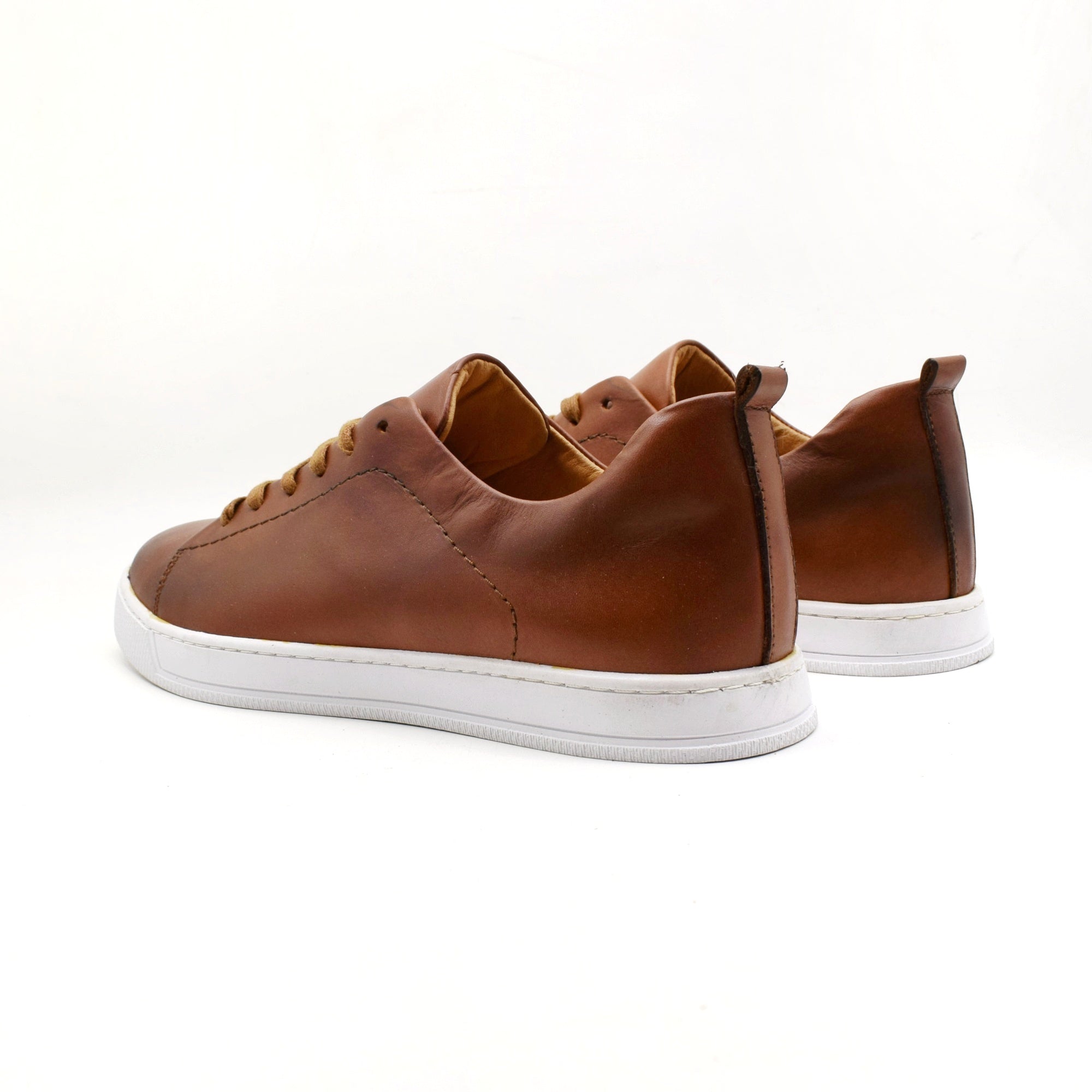 Brown leather sneakers with white soles on a white background