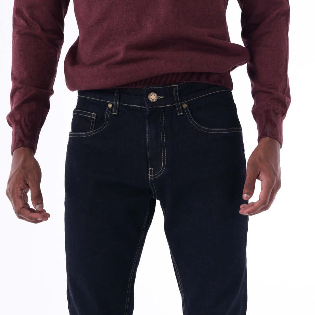 Navy slim denim jeans with contrast beige stitching, styled with a maroon sweater.