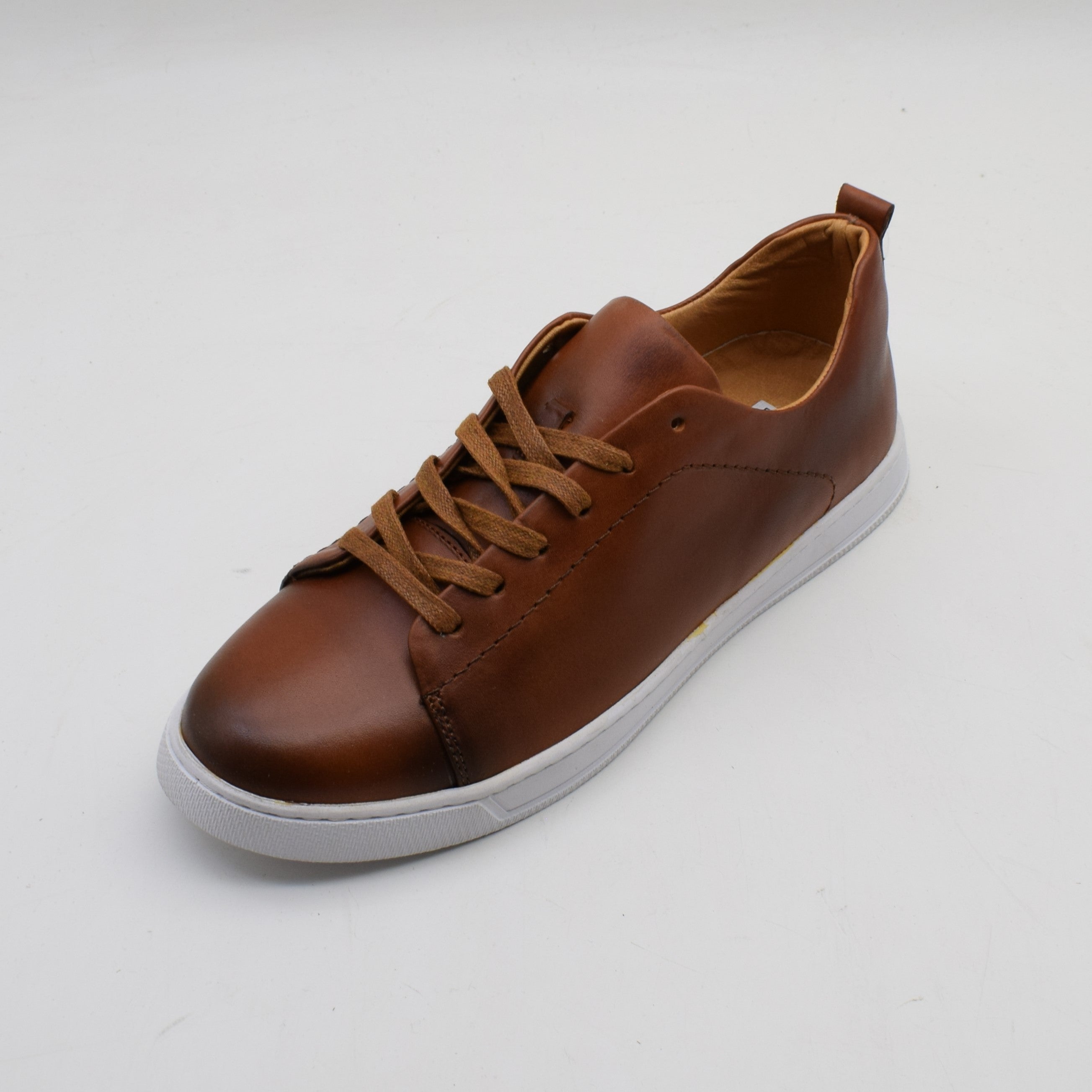 Brown leather sneaker with white sole on a light gray background